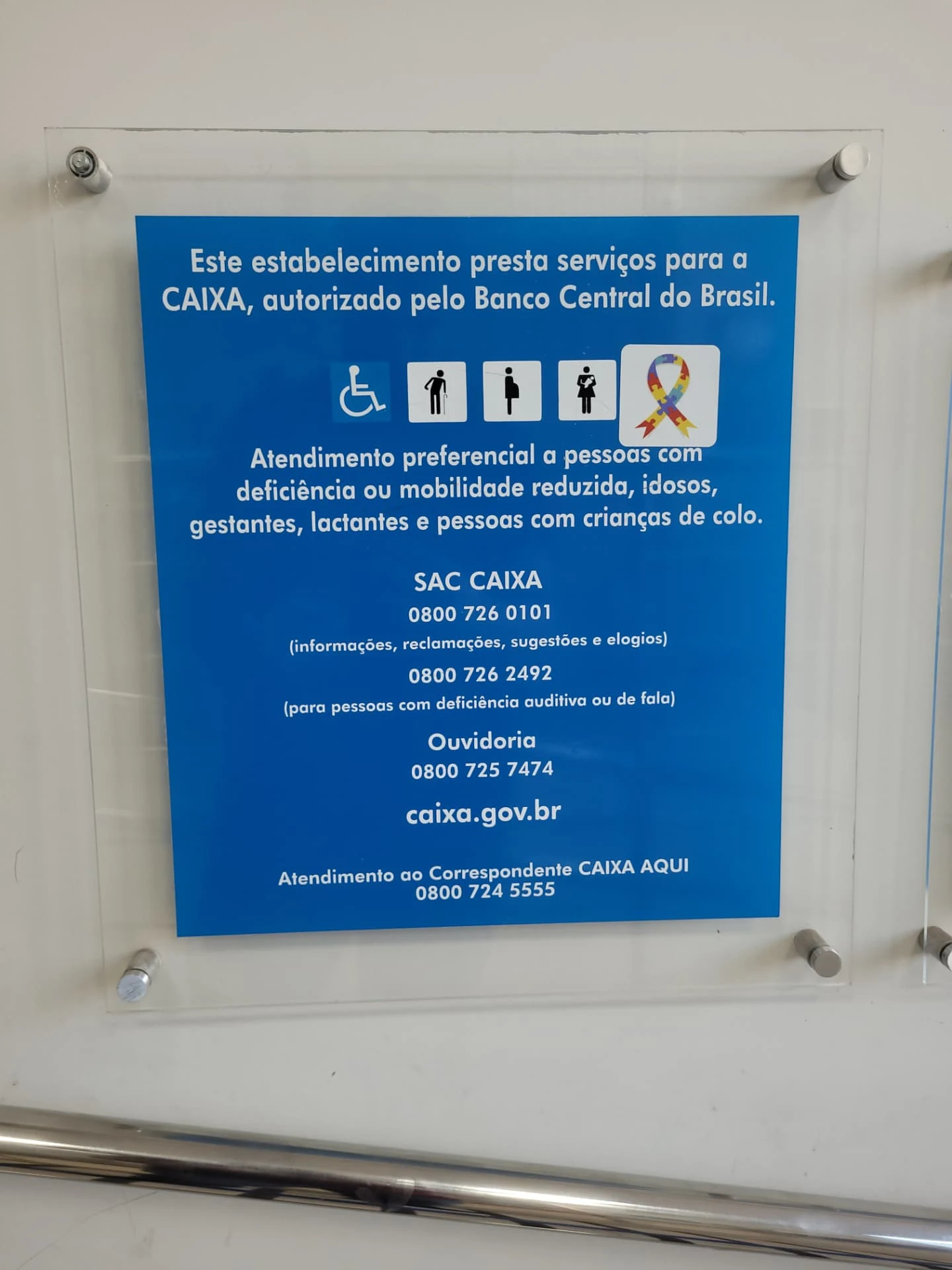 Placa com informações sobre atendimento preferencial e serviços Caixa
